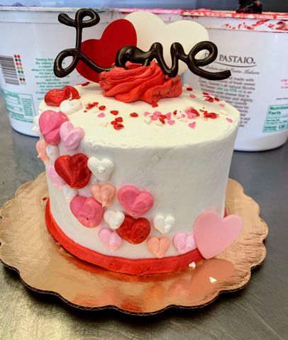 white cake with hearts and the word love on top