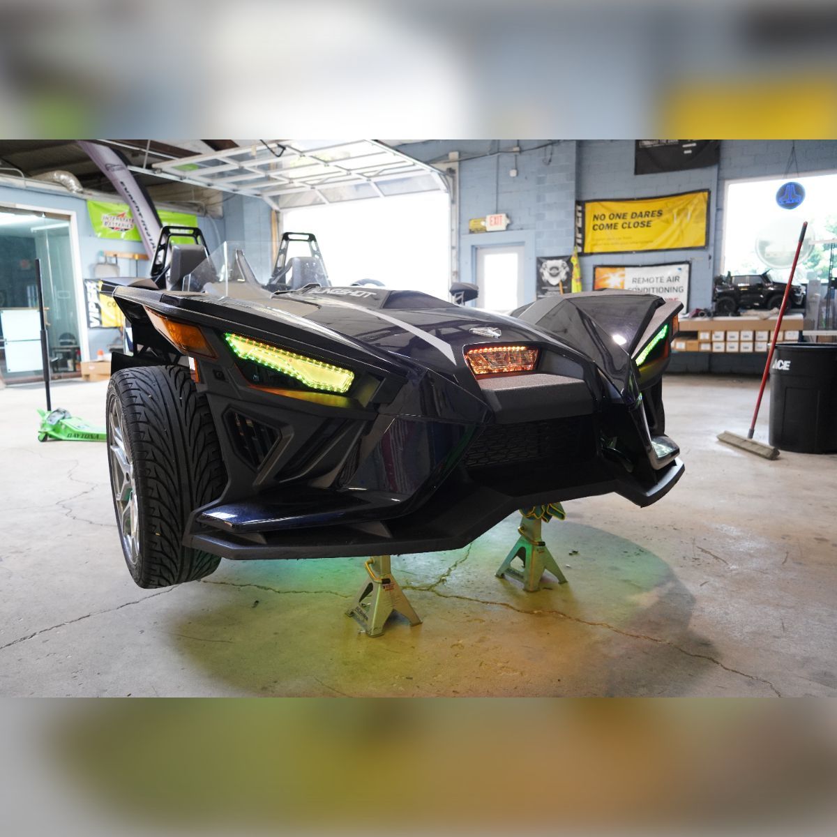 A black slingshot is parked in a garage