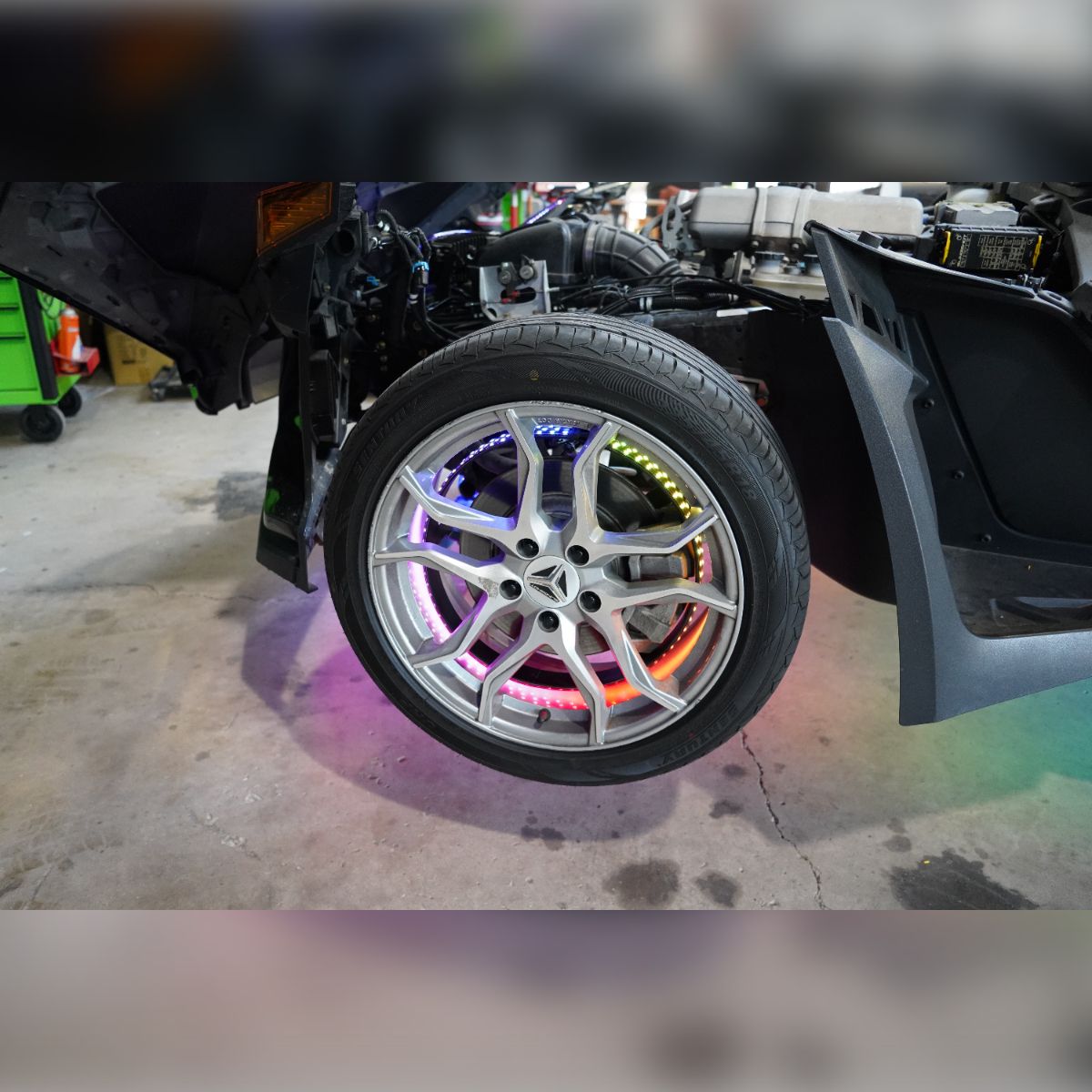 A close up of a car wheel with a rainbow colored rim