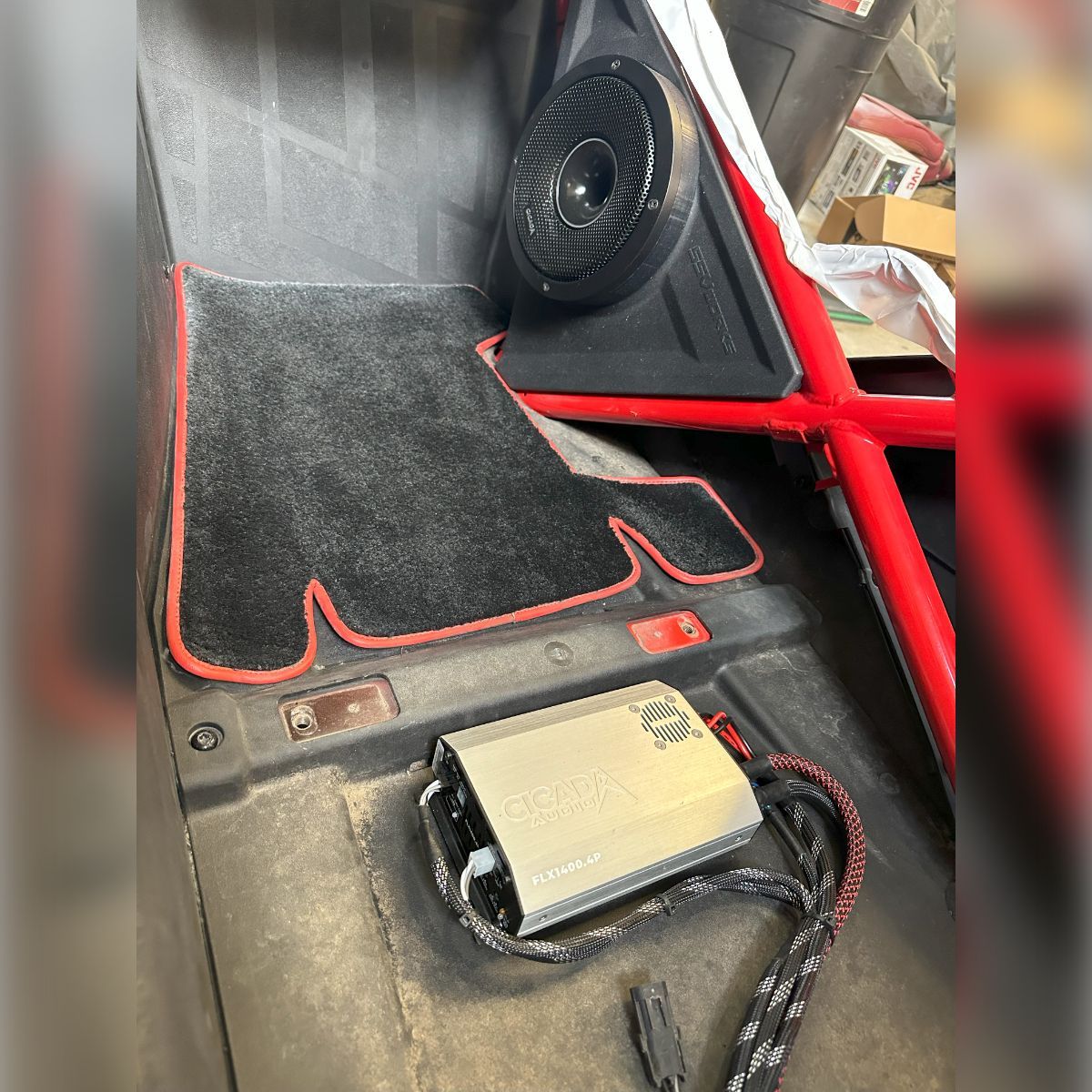 A car with a speaker and a charger on the floor.