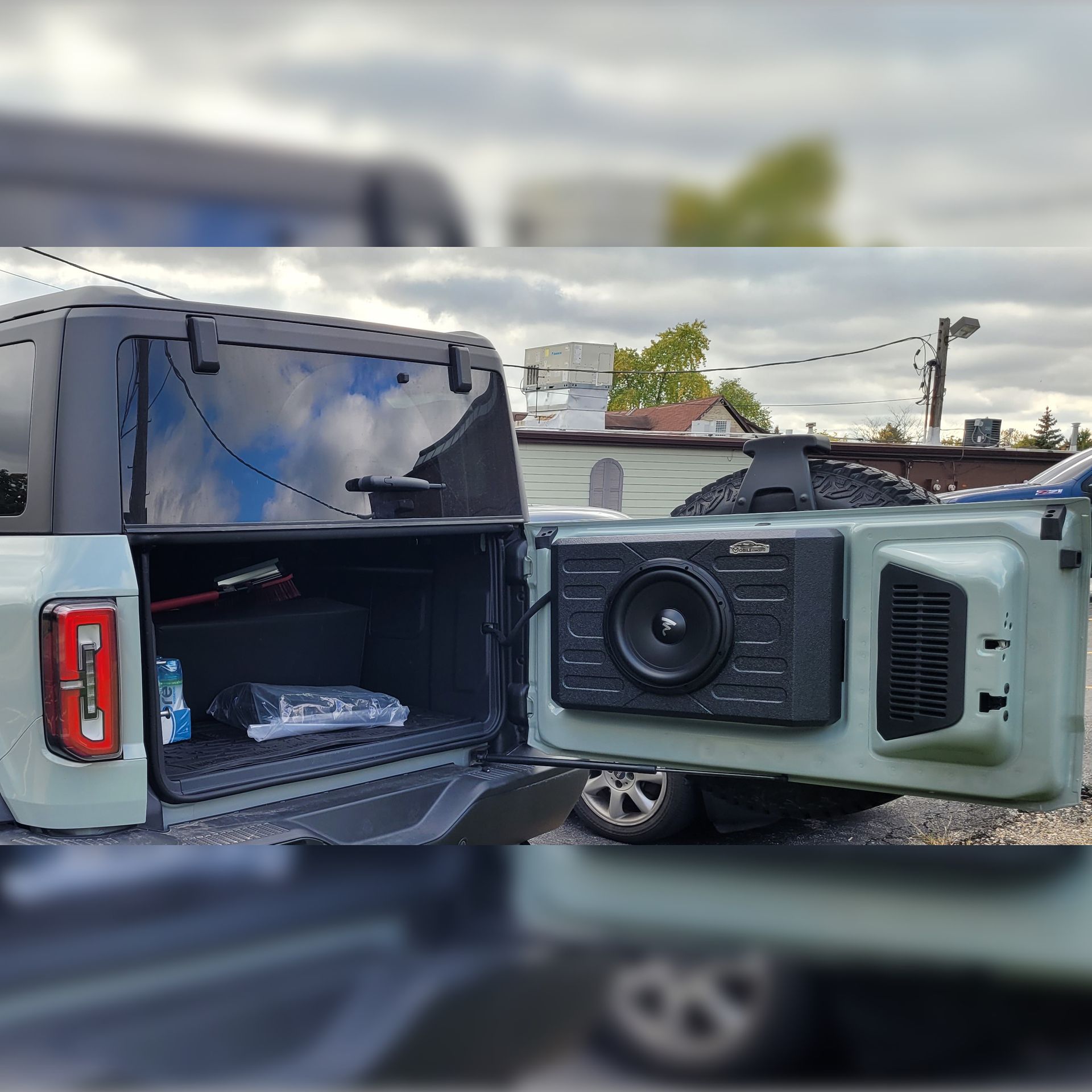 A jeep with a speaker attached to the back of it