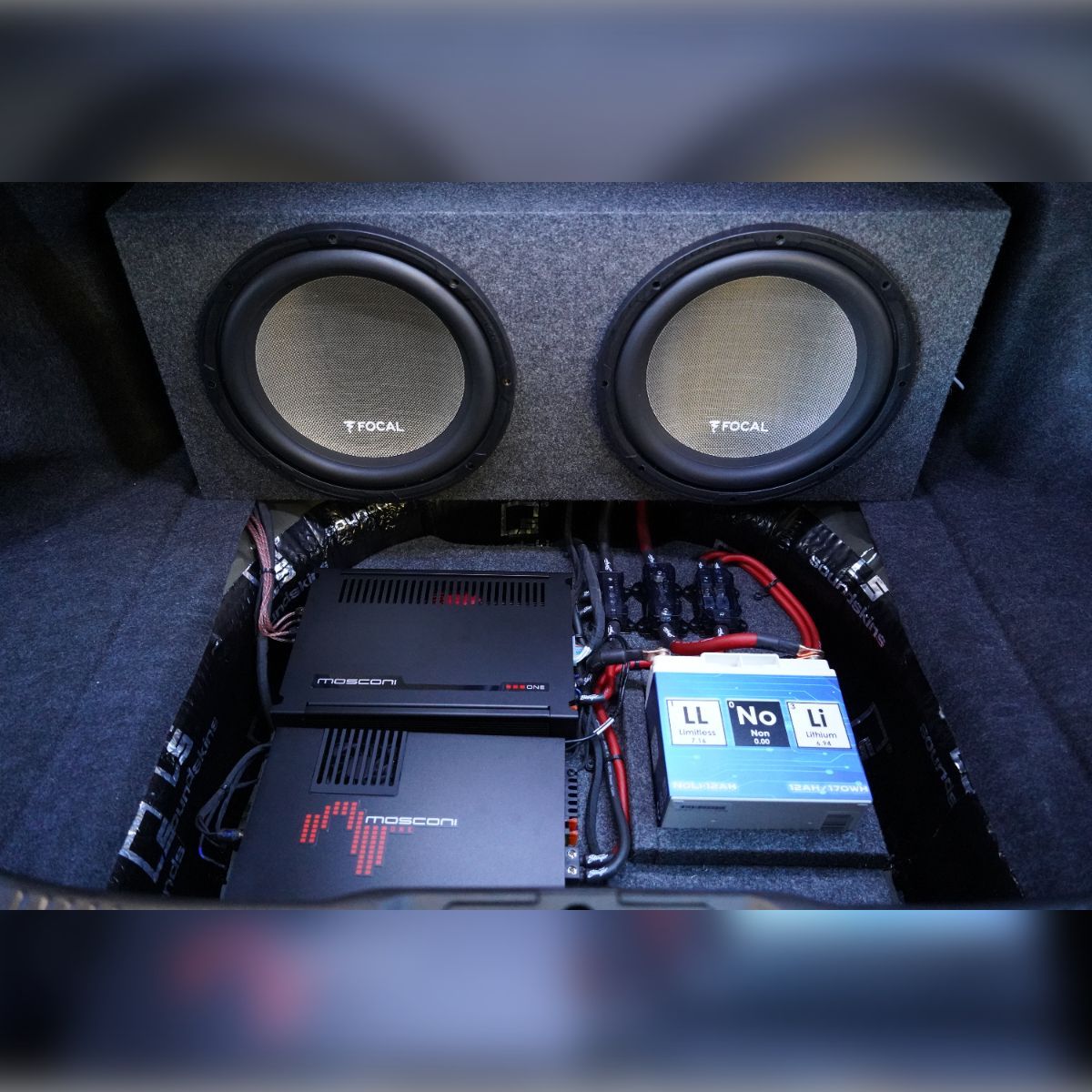 A subwoofer is sitting in the trunk of a car