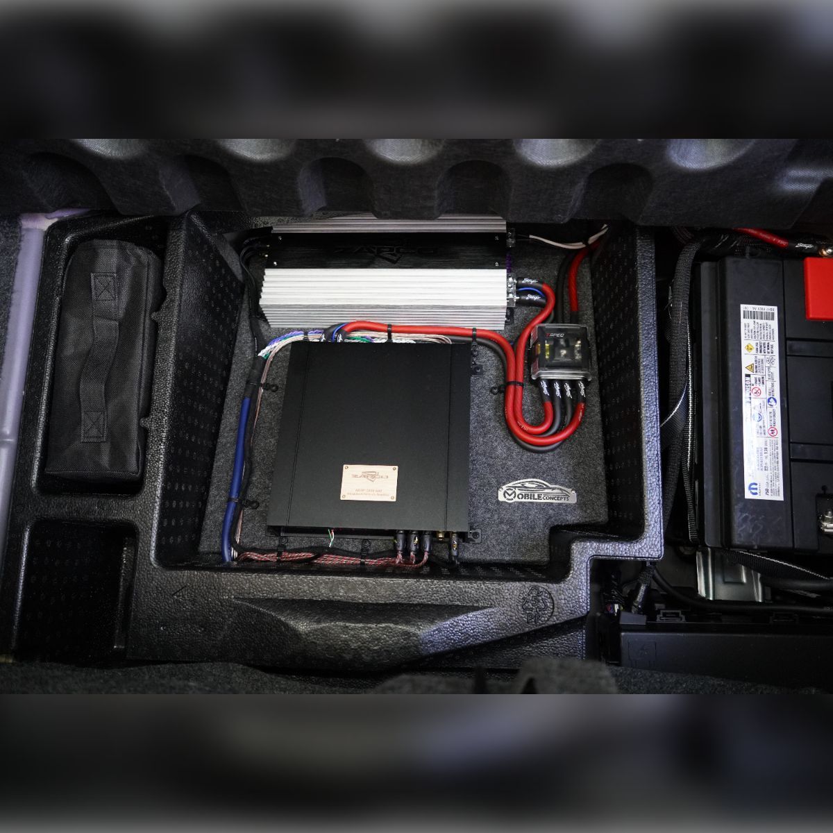 A black box is sitting in the trunk of a car.