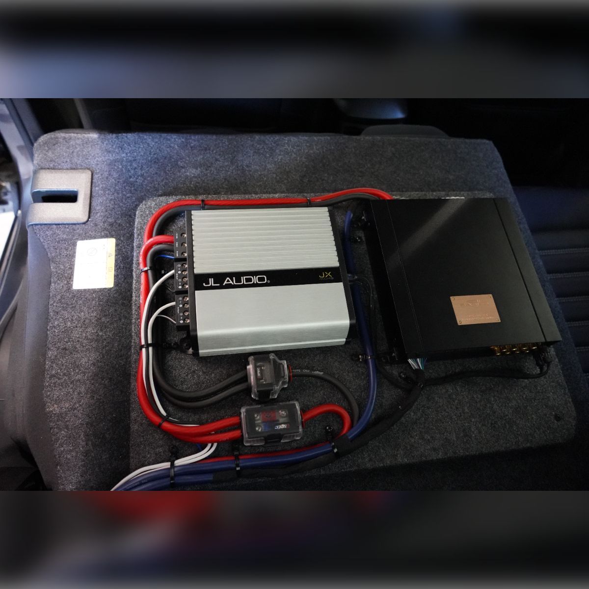 A j audio amplifier sits in the trunk of a car