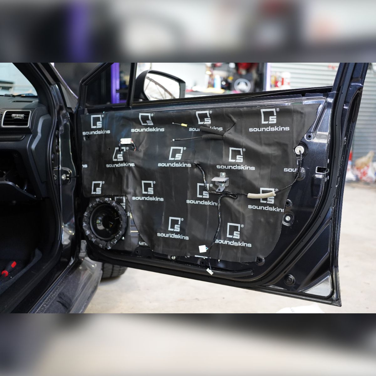 A close up of a car door with a speaker in it
