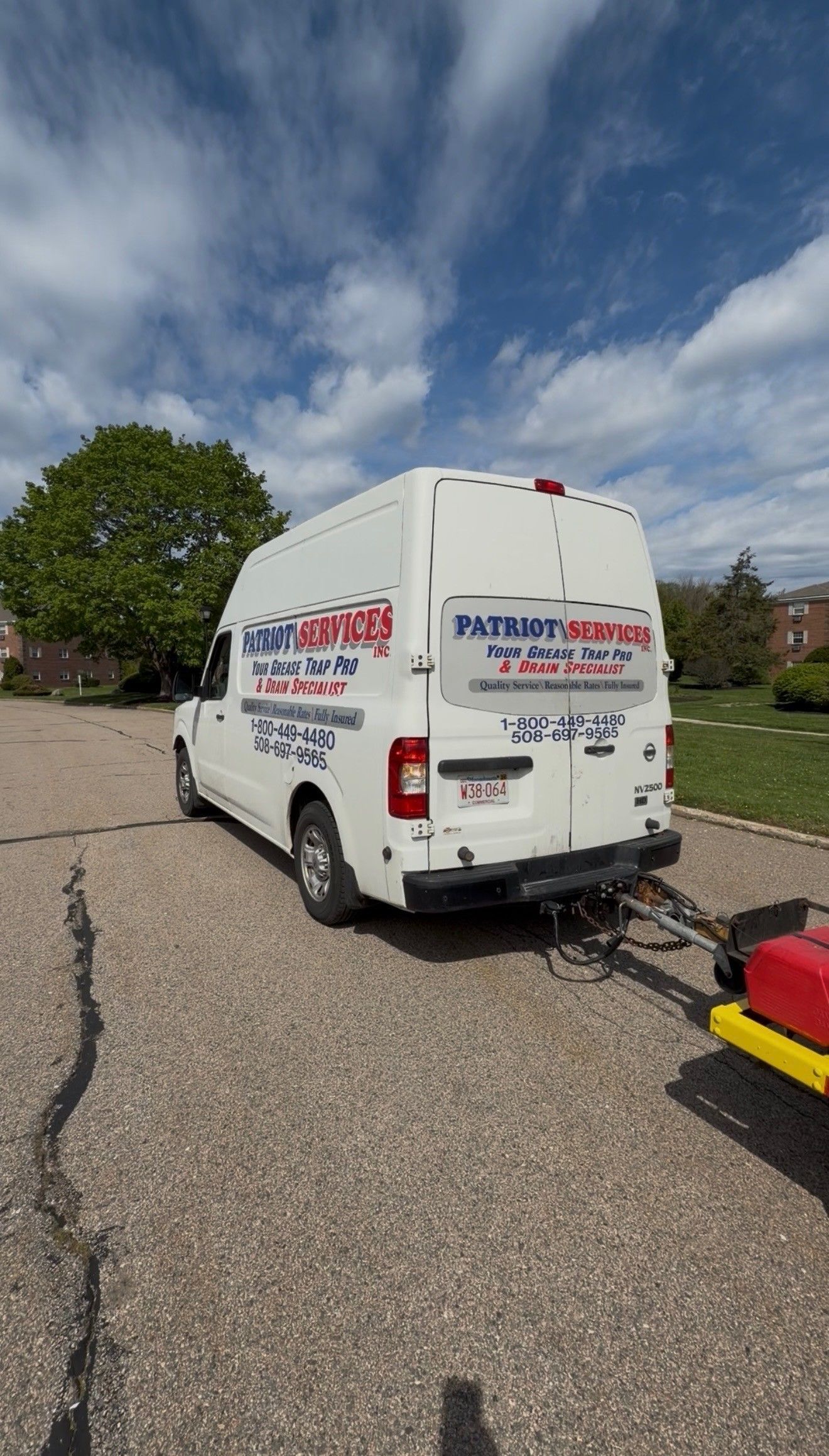 White van parked on a gravel driveway under a partly cloudy sky, with a tree and lawn nearby