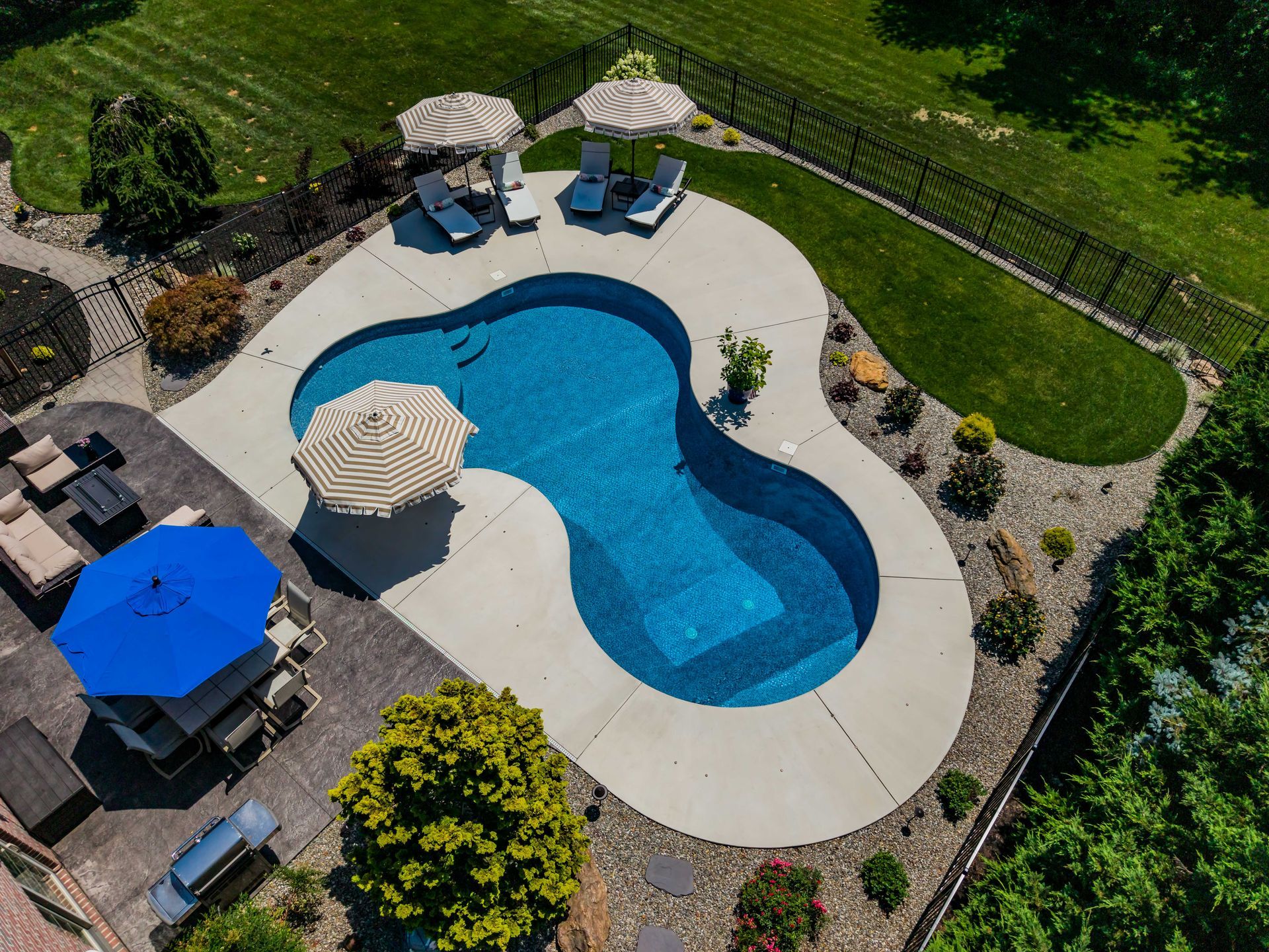 An aerial view of a large swimming pool with umbrellas and chairs