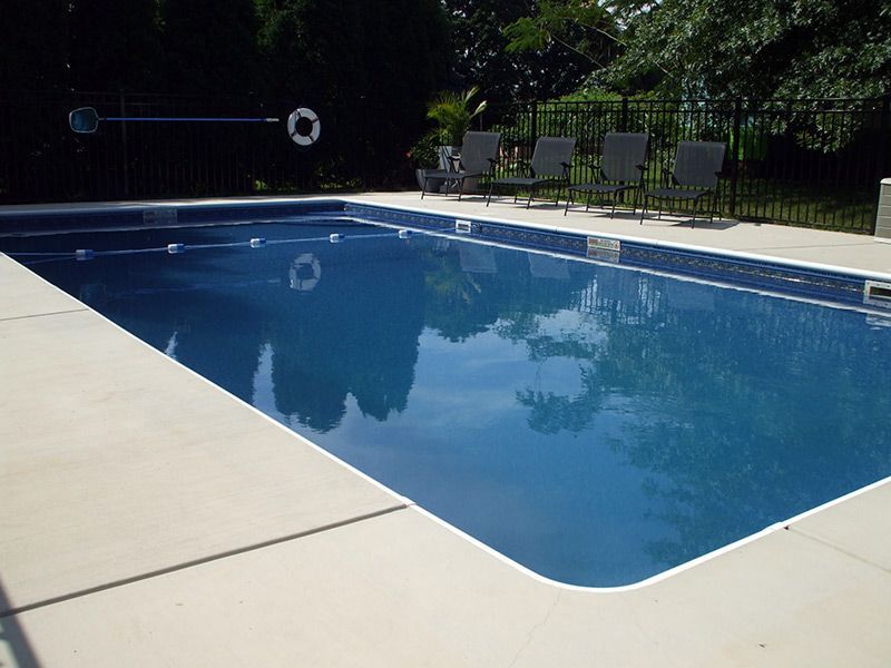 A large swimming pool surrounded by chairs and a life preserver