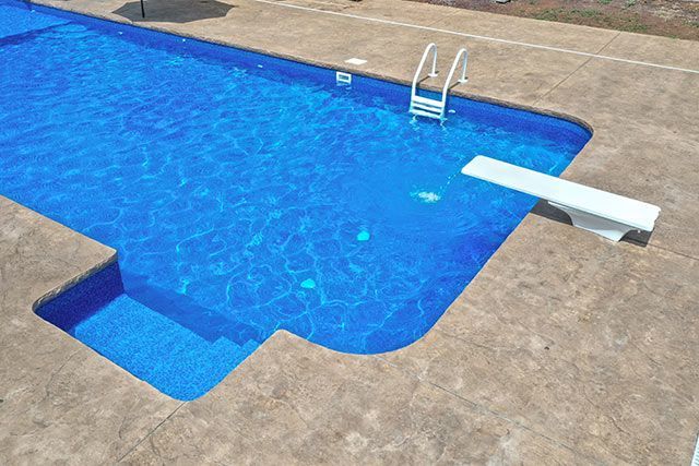 There is a diving board in the middle of the pool.