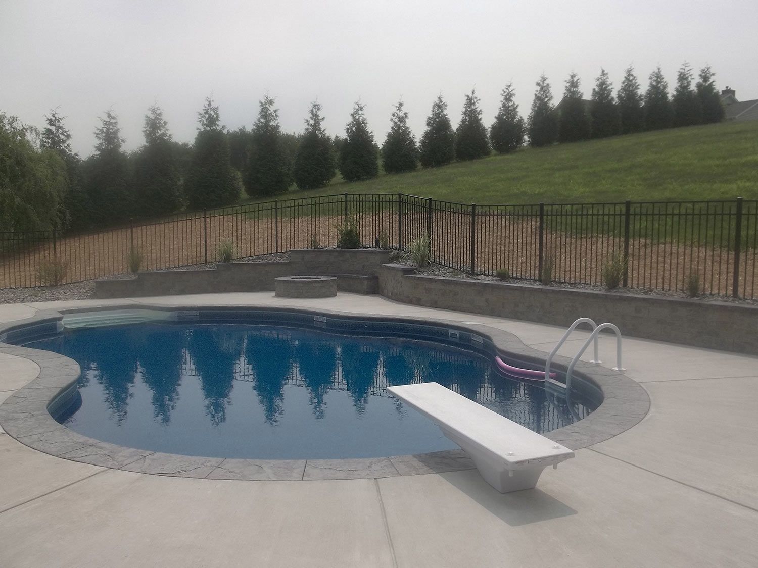 A large swimming pool with a diving board in the middle