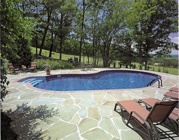 A large swimming pool surrounded by chairs and trees