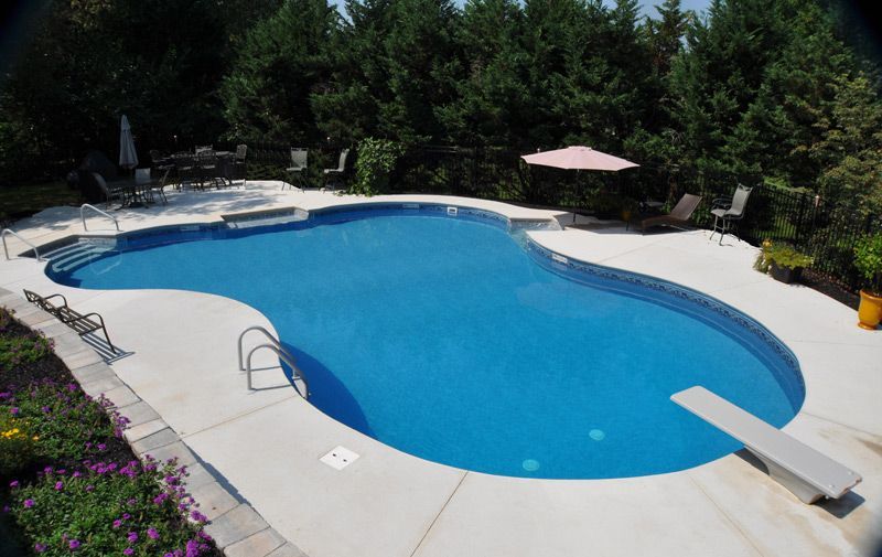 A large swimming pool with a diving board in the middle