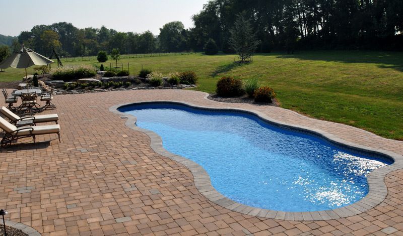 A large swimming pool surrounded by chairs and umbrellas
