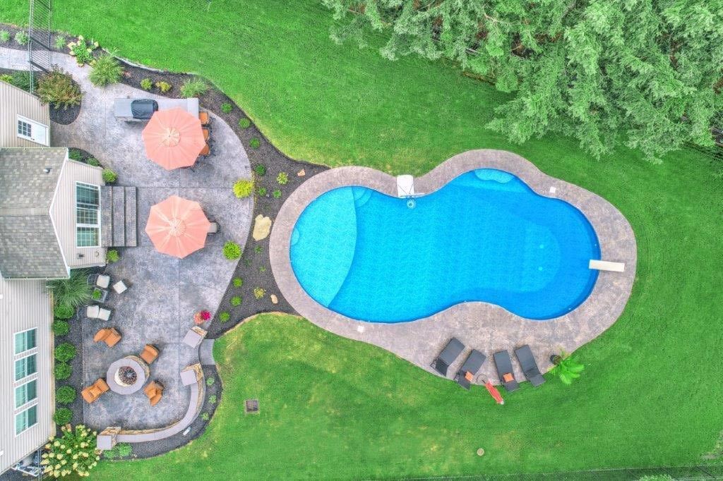 An aerial view of a large swimming pool in a backyard.