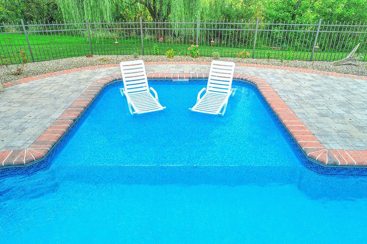 Two lounge chairs are floating in a swimming pool.