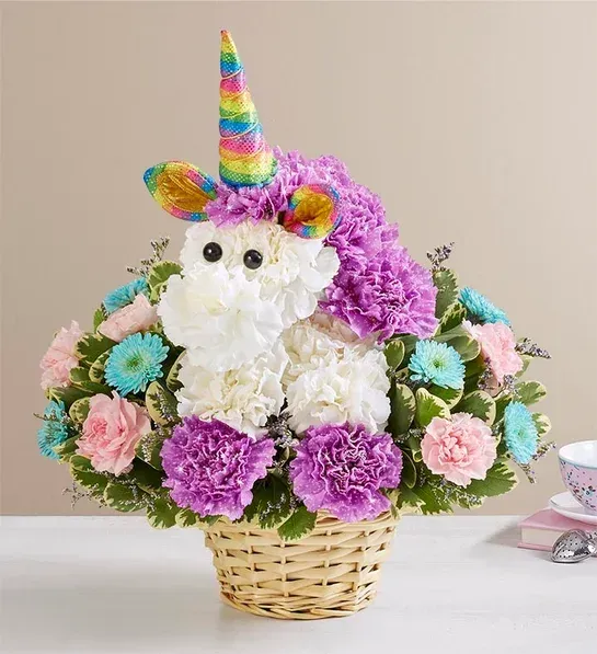 A unicorn made out of flowers in a basket on a table.