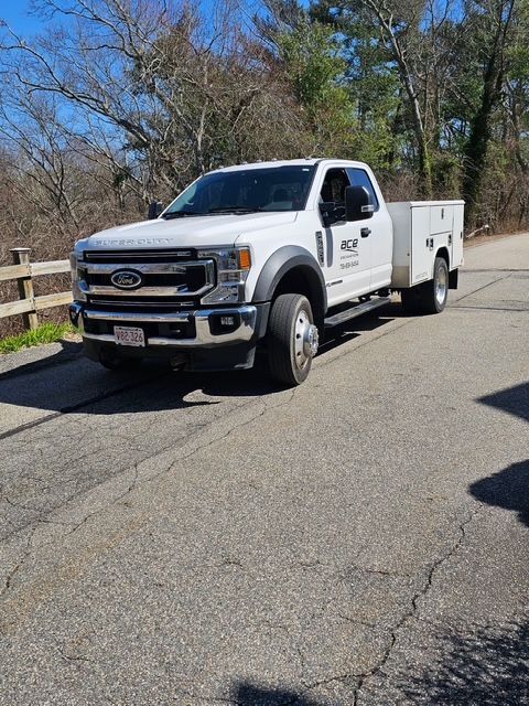 A white ford truck is parked on the side of the road.
