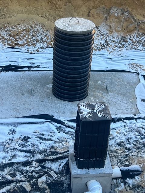 A stack of plastic pipes sitting on top of a concrete block