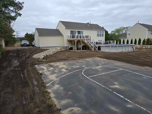A house with a basketball court in front of it