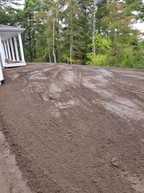A large pile of dirt is sitting in front of a house.