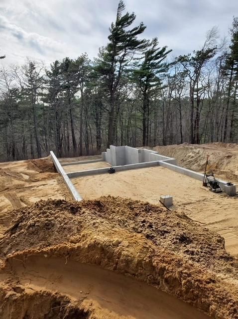A construction site with a lot of dirt and trees in the background.