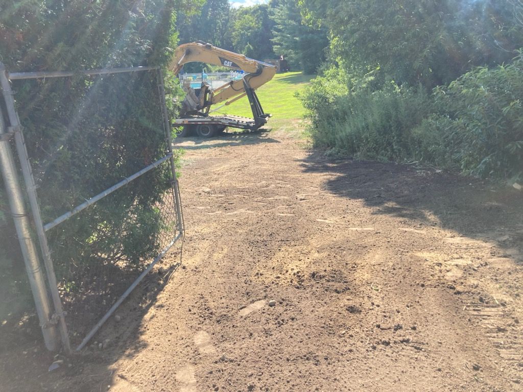 A large excavator is parked on the side of a dirt road.