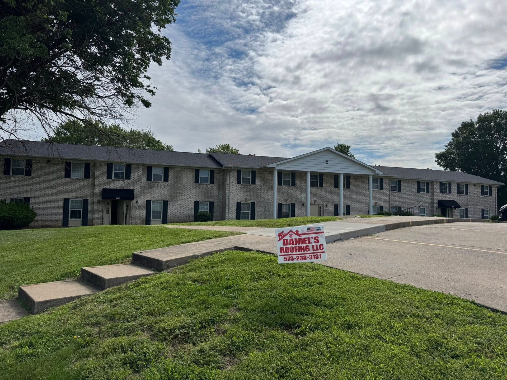 A large apartment building with a for sale sign in front of it.