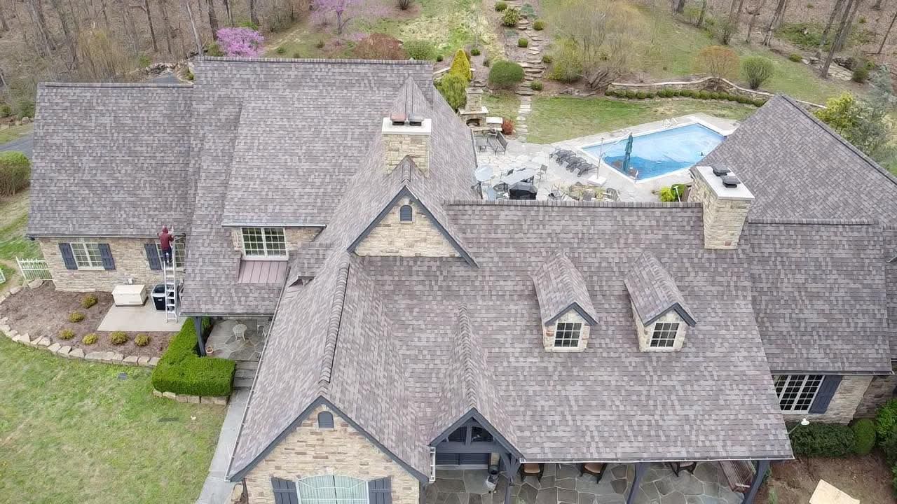 An aerial view of a large house with a pool in the backyard.