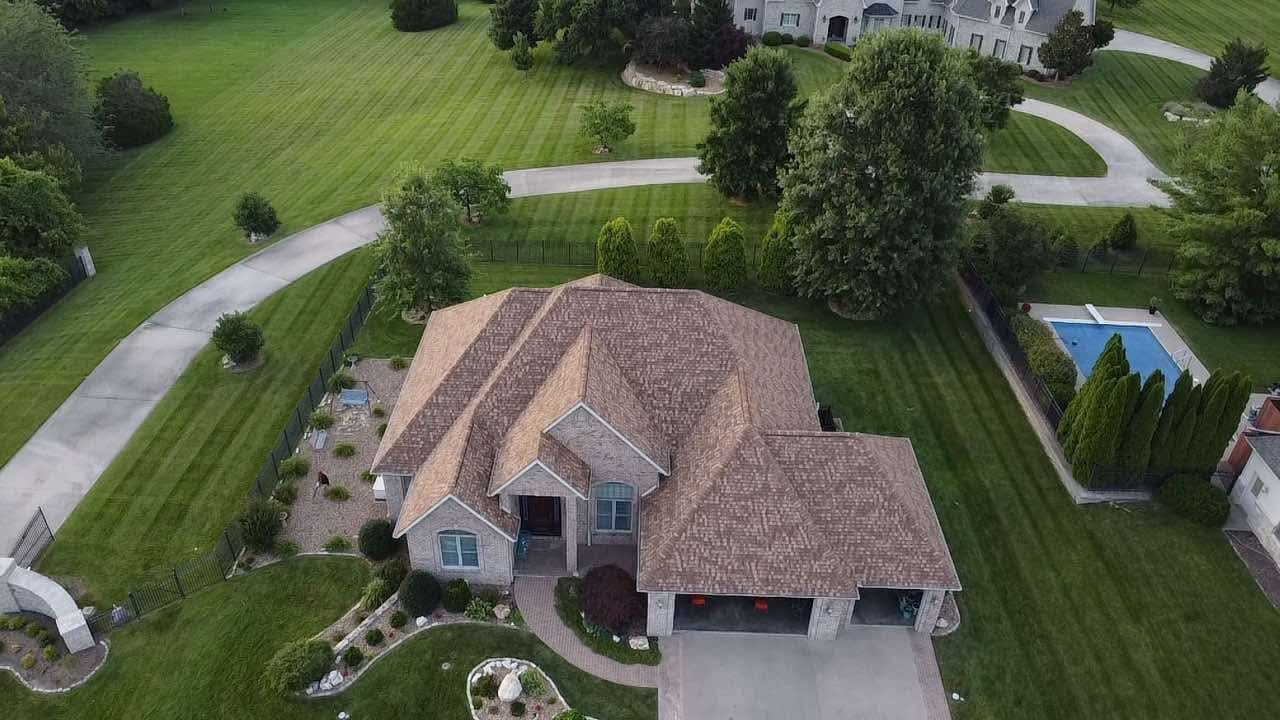An aerial view of a large house with a pool in the backyard.