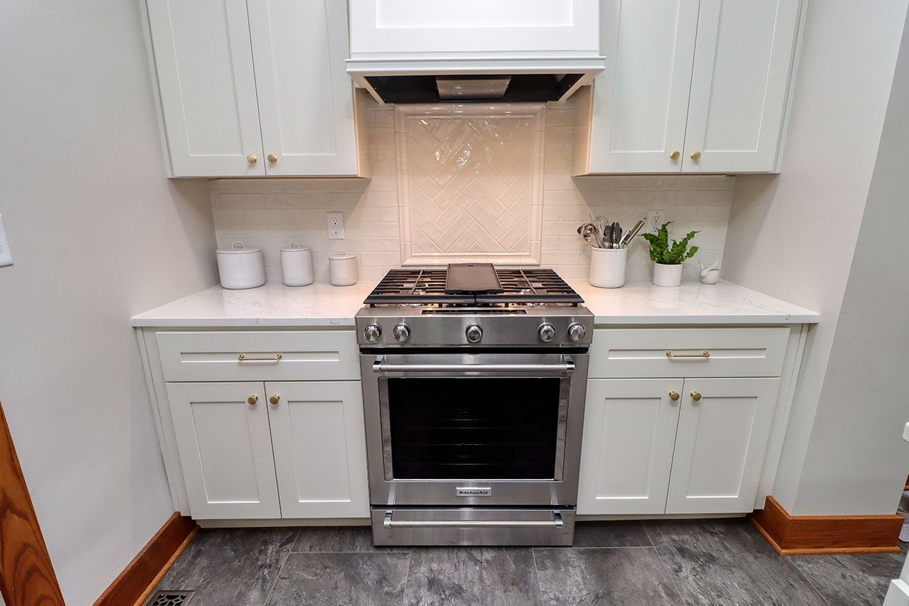 A kitchen with stainless steel appliances and white cabinets.