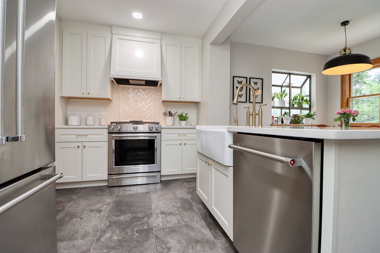 A kitchen with stainless steel appliances and white cabinets.