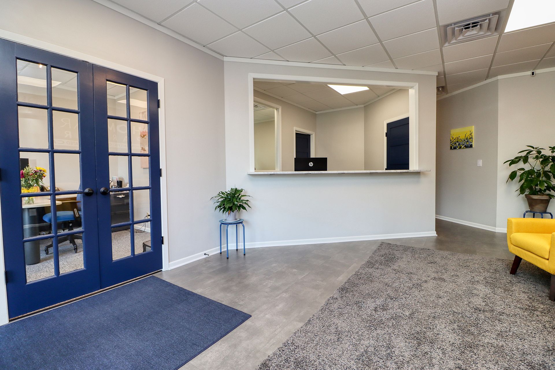 A living room with a yellow chair and a blue door