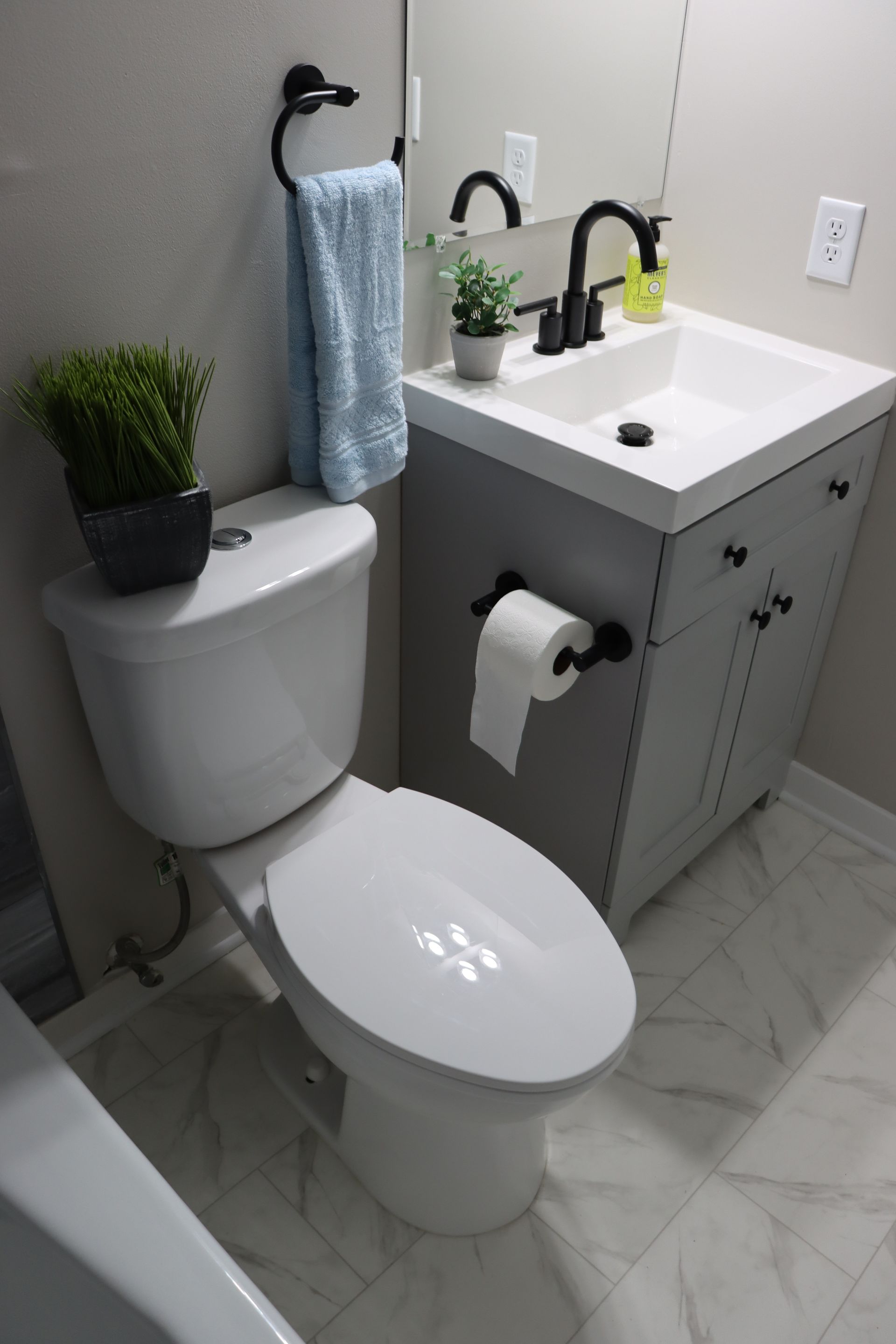 A bathroom with a toilet , sink and mirror