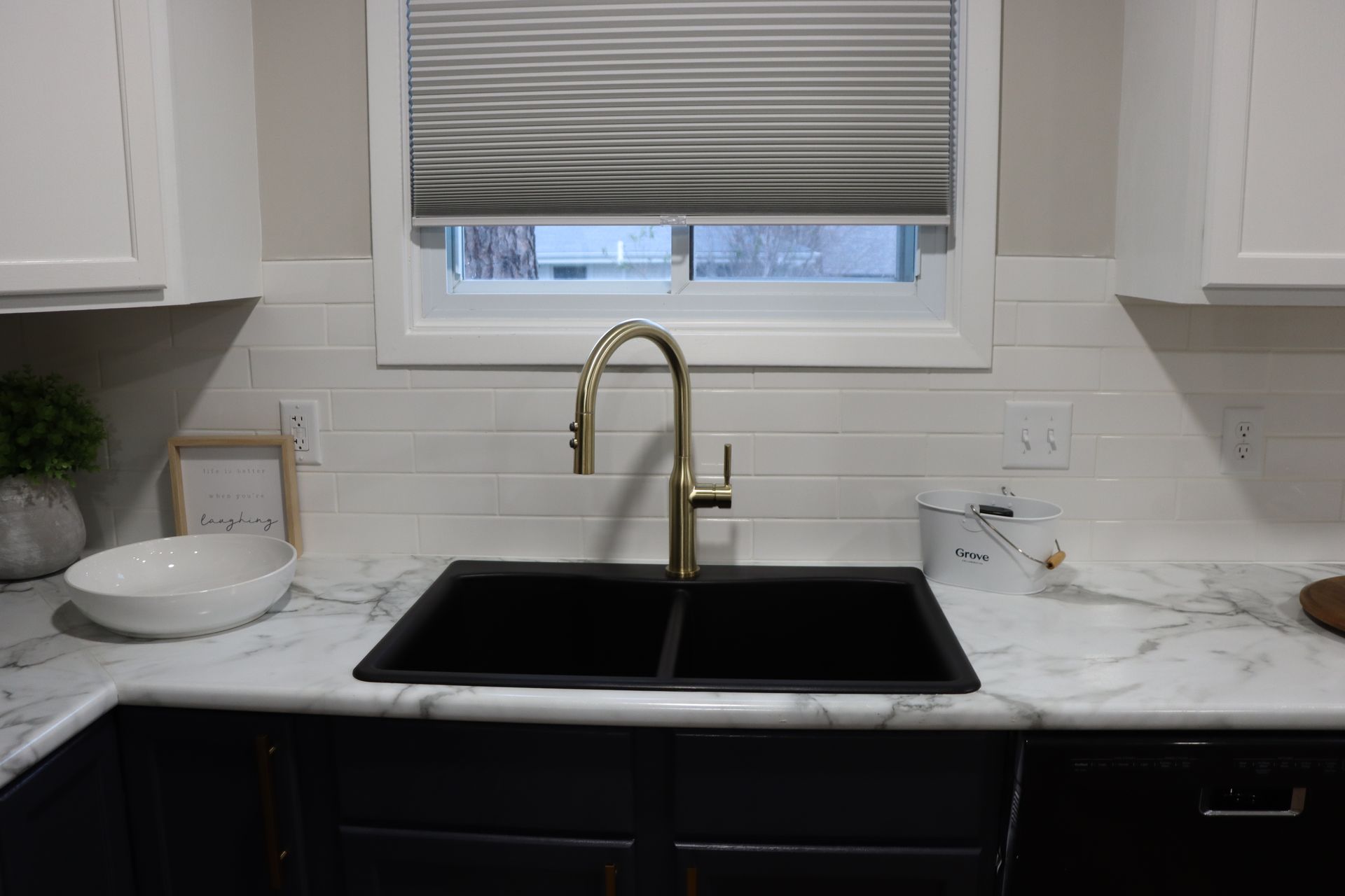 A kitchen sink with a faucet and a window.