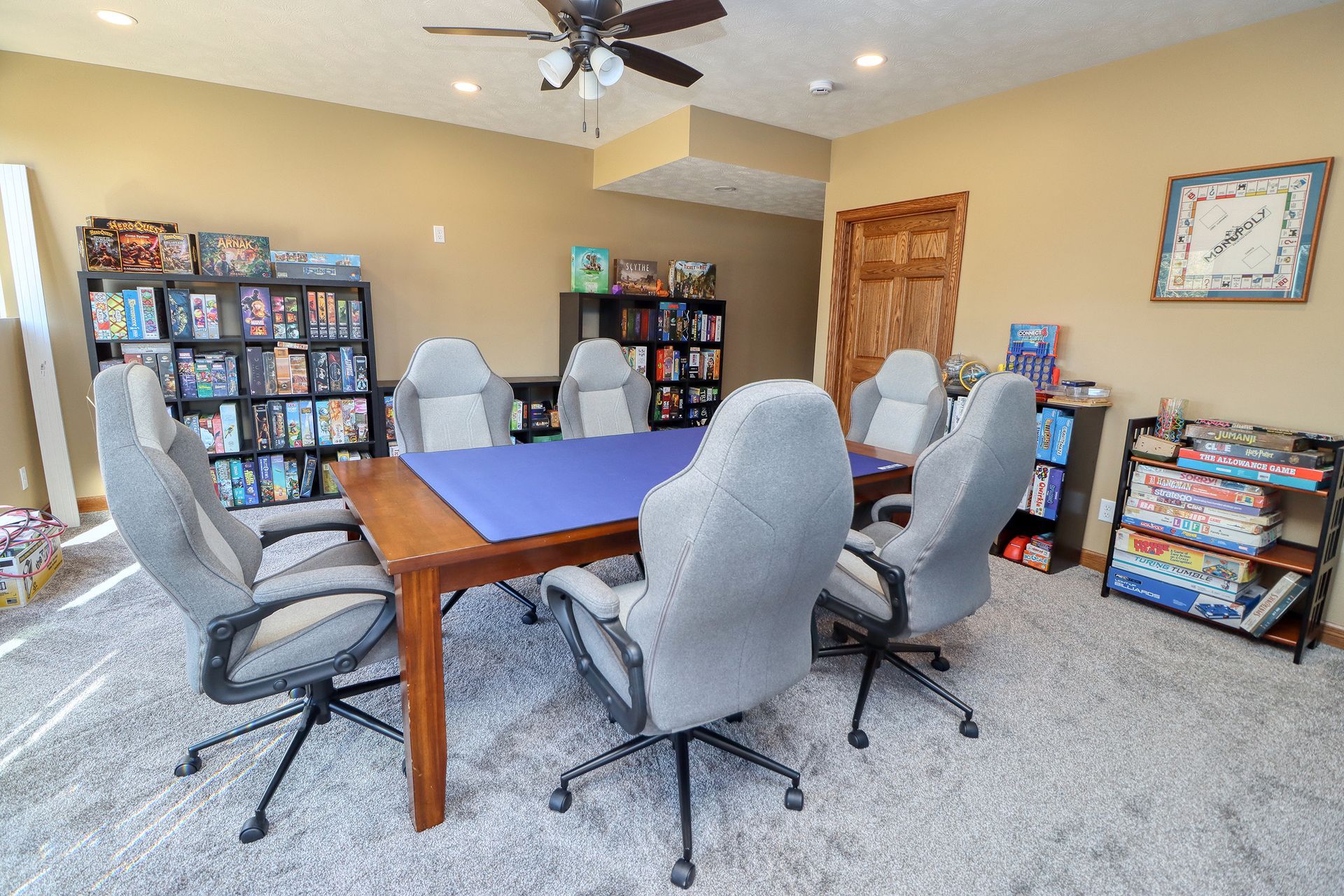 A room with a table and chairs and a ceiling fan.