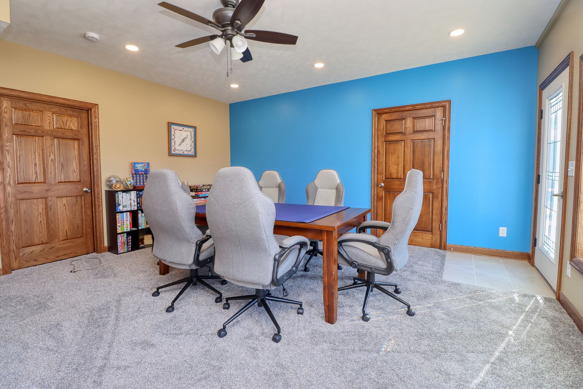 A conference room with a table and chairs and a ceiling fan.