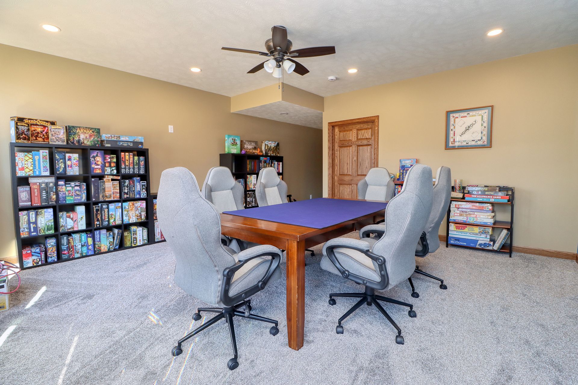 A game room with a table and chairs and a ceiling fan.