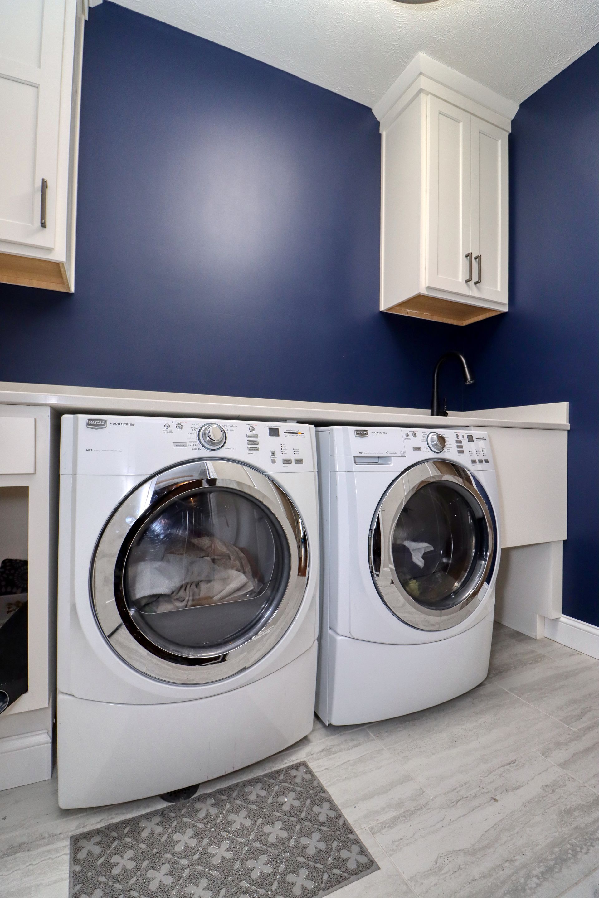 A laundry room with a washer and dryer and blue walls.