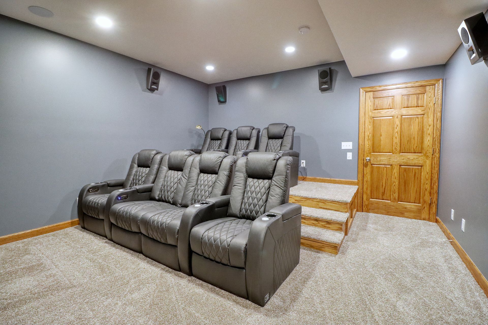 A home theater with a couch and chairs in it.