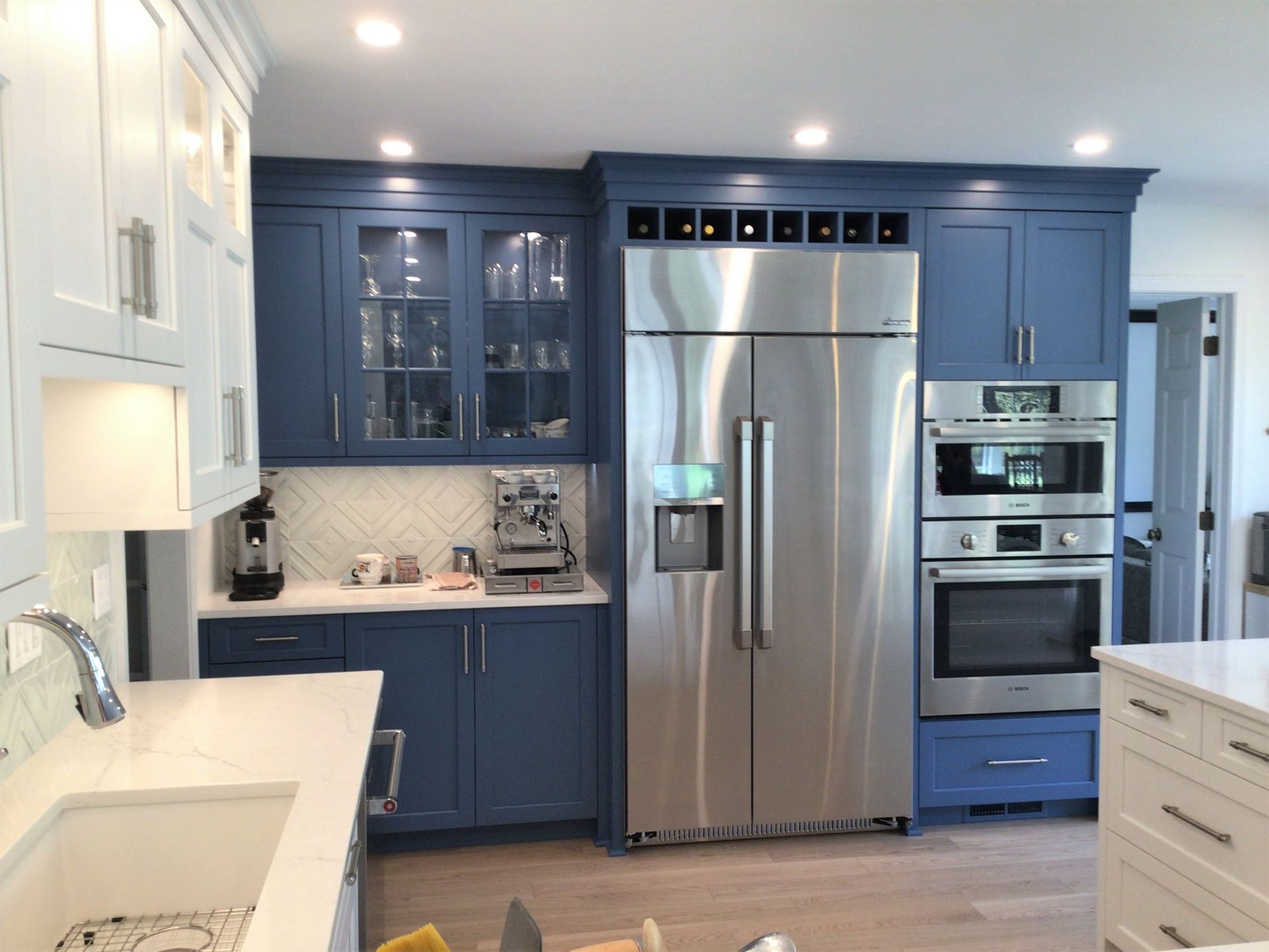 a kitchen with blue cabinets and stainless steel appliances