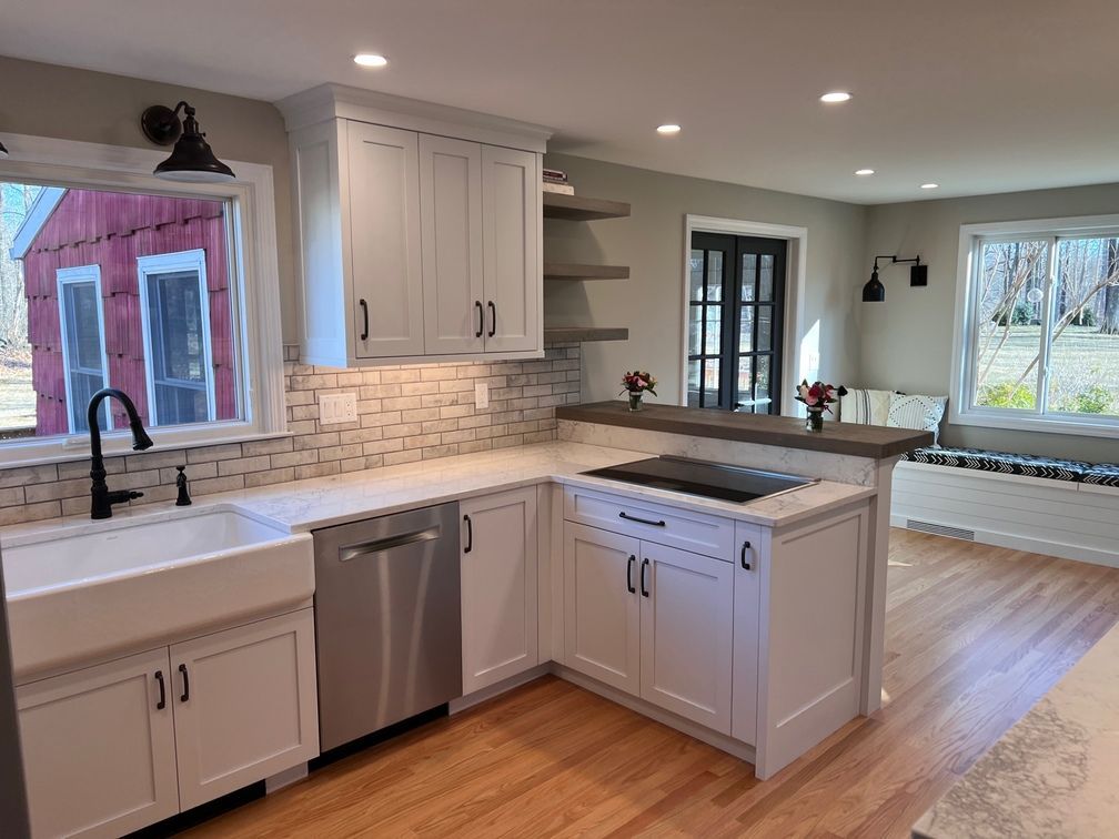 a kitchen with white cabinets, stainless steel appliances, a sink and a window