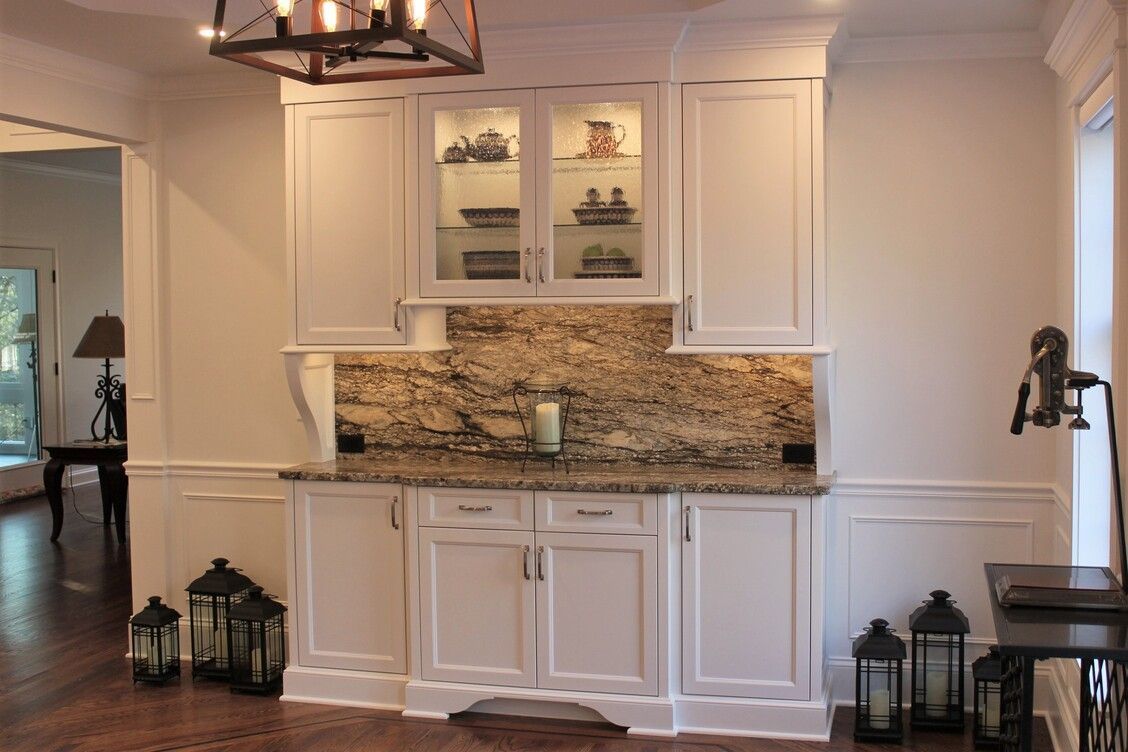 a kitchen with white cabinets, granite counter tops, and lanterns