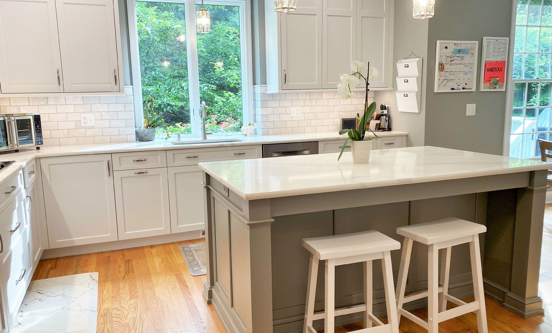 a kitchen with white cabinets and a large island with stools