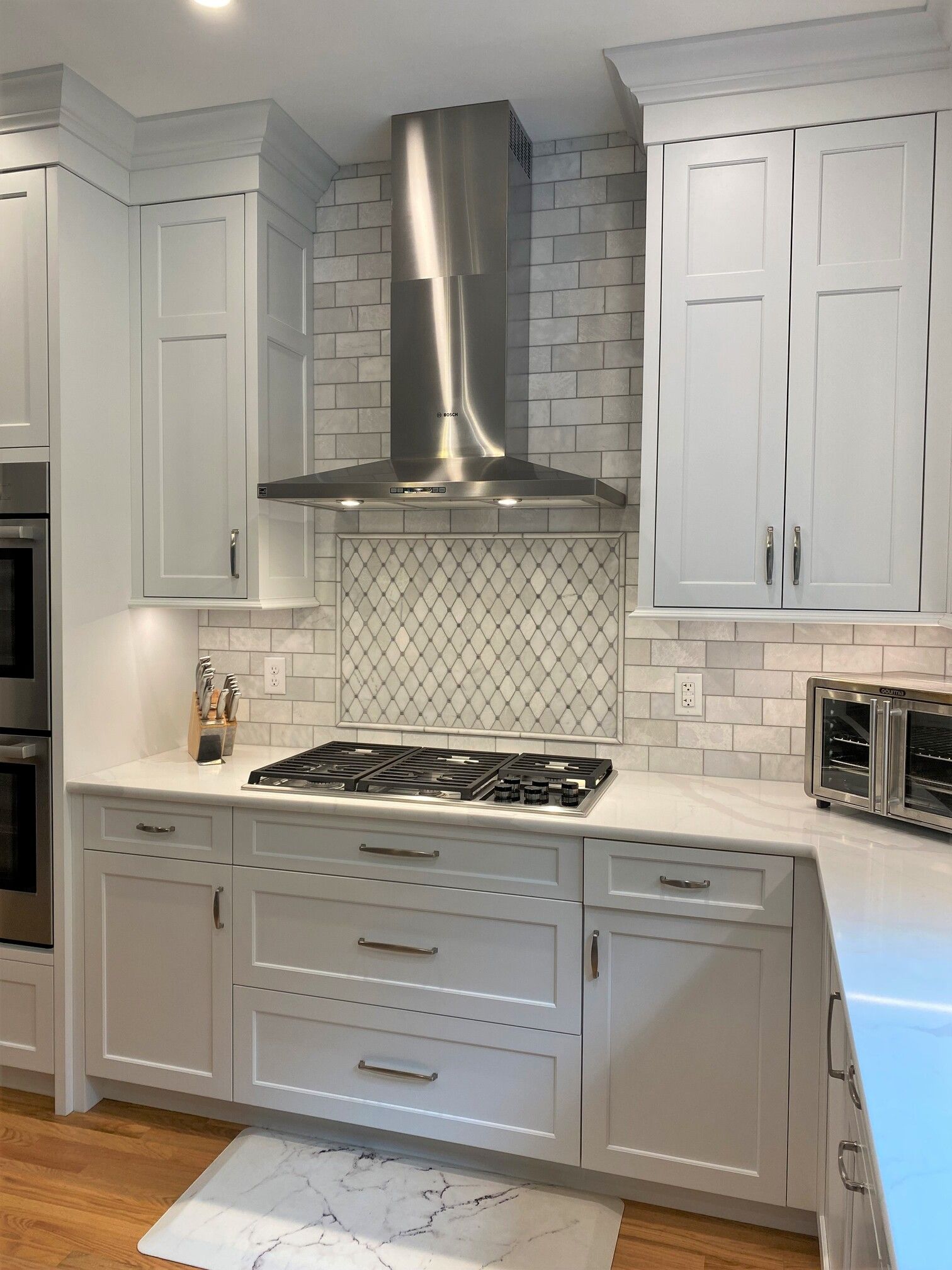 a kitchen with white cabinets and a stove top oven