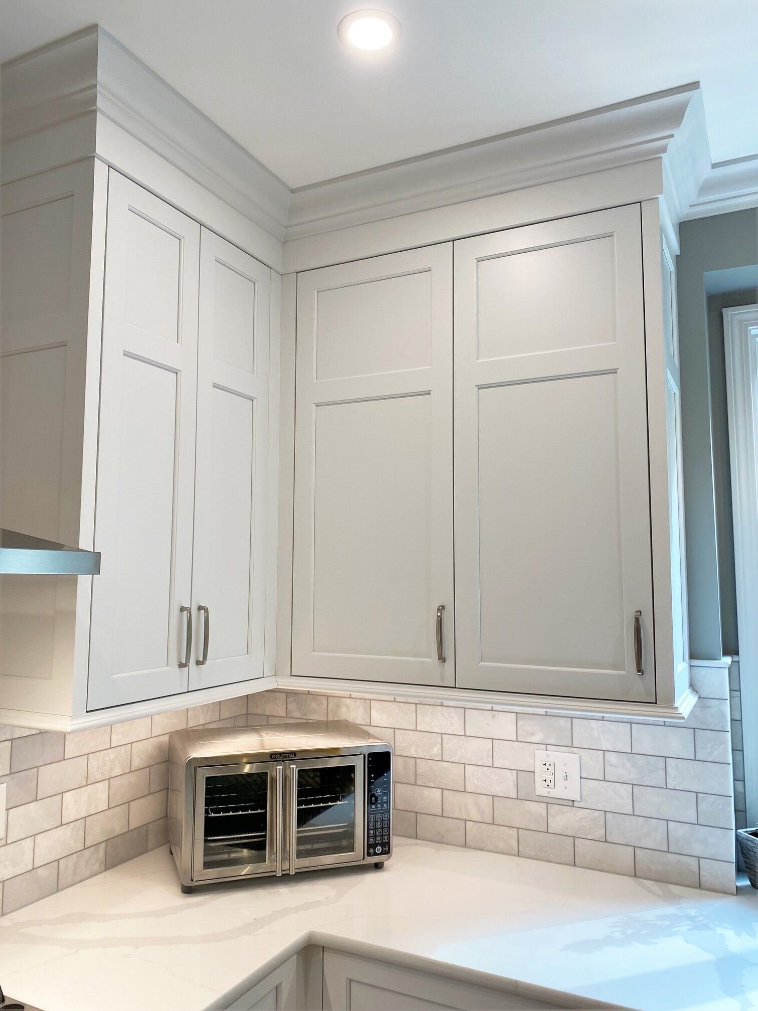 a kitchen with white cabinets and a microwave on the counter