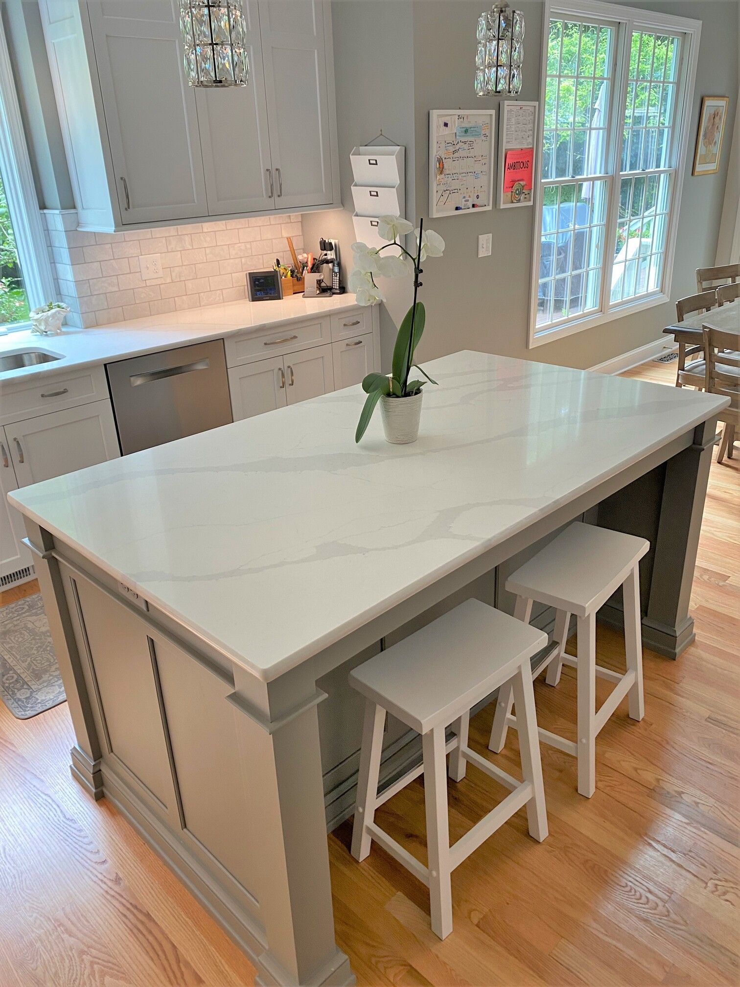 a kitchen with a large island and white stools