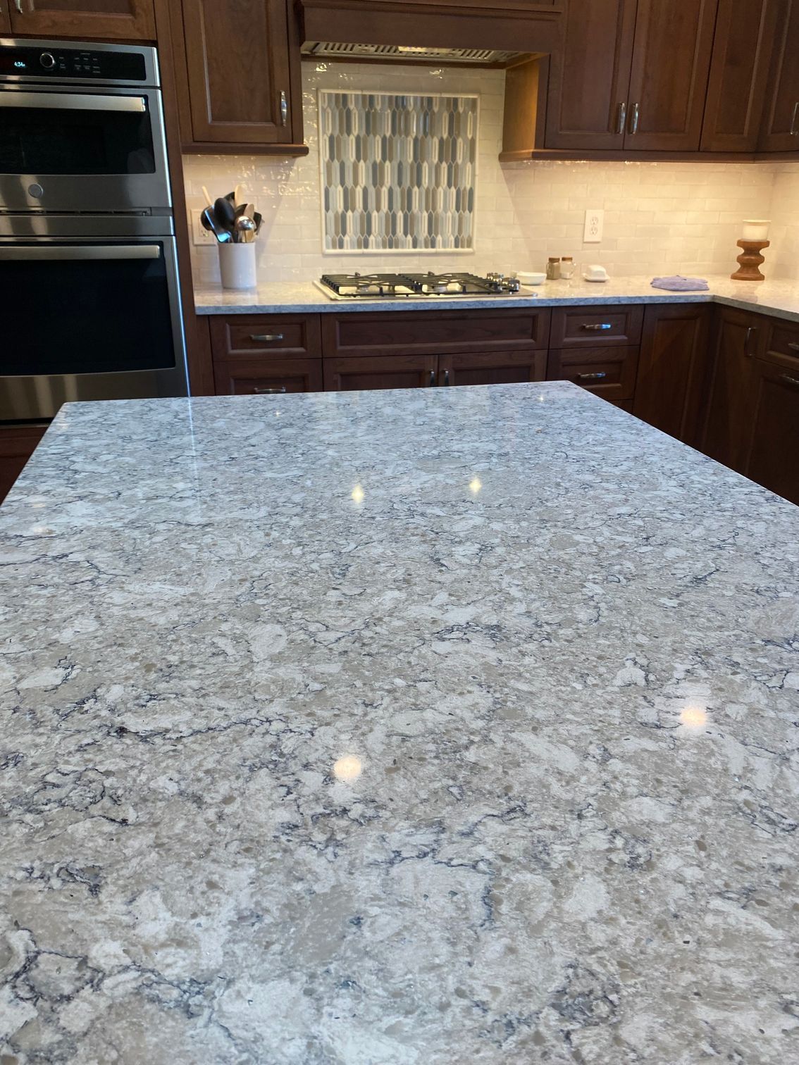a kitchen with a large granite counter top and stainless steel appliances