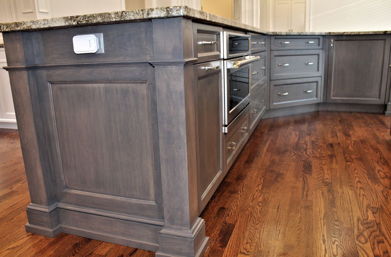 a kitchen with gray cabinets and hardwood floors and a large island