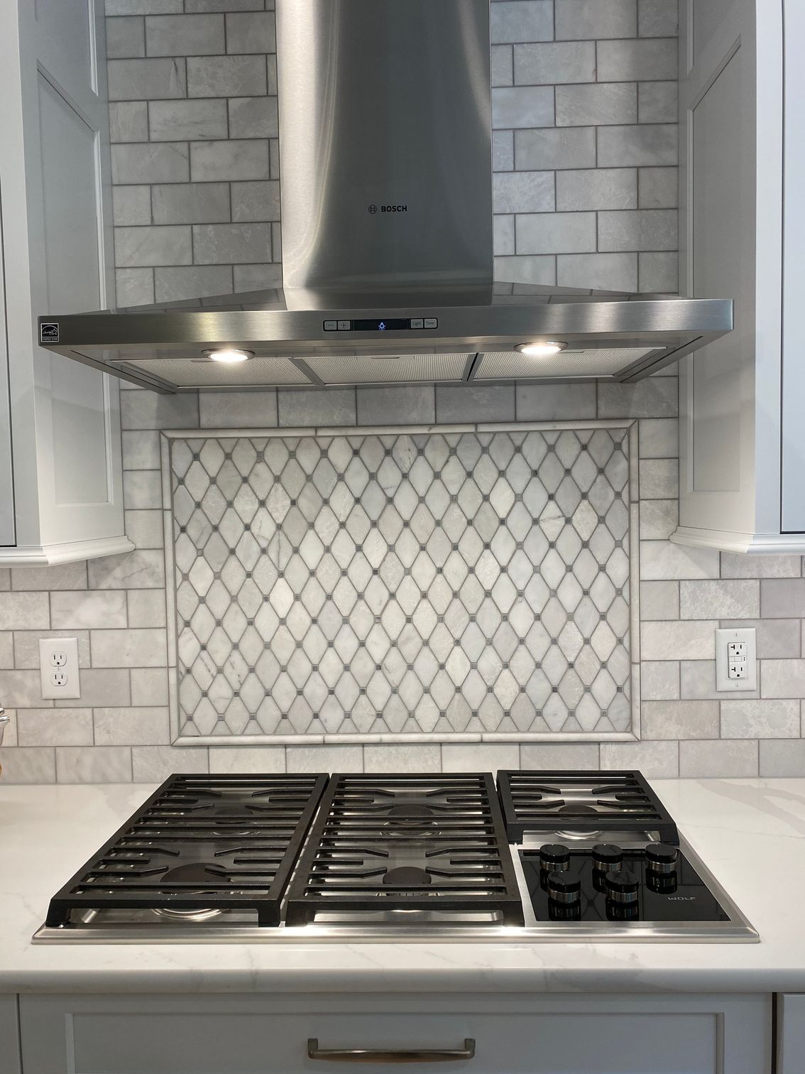 a kitchen with a stove top oven and a hood above it