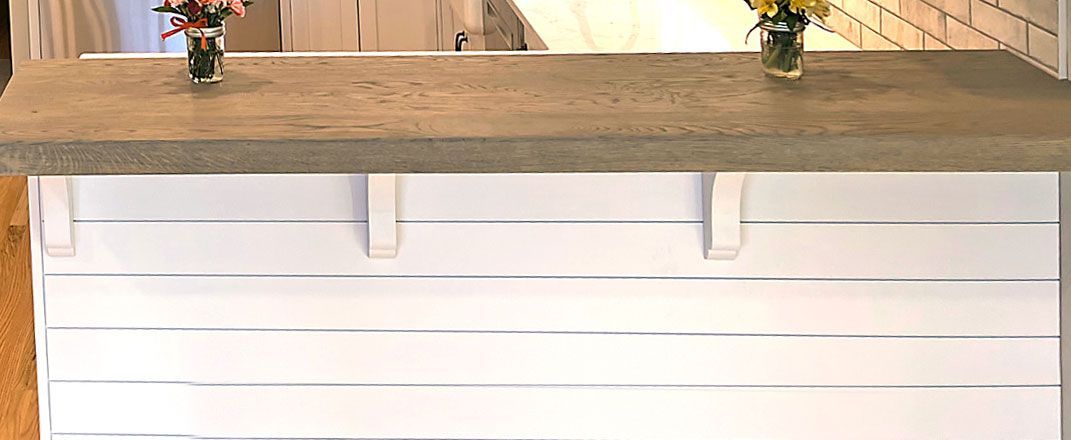 a counter top with two vases of flowers on it